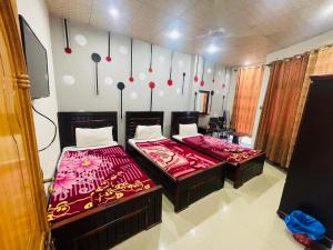 two beds sitting next to each other in a room at Green land hotel in Mingāora +12 photos