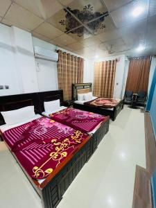 2 letti in una camera con lenzuola viola di Green land hotel a Mingora Altre 11 foto