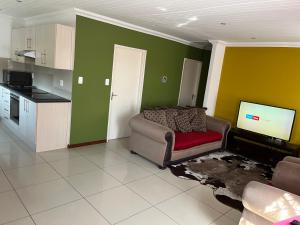 a living room with a couch and a flat screen tv at SNE Travellers in Faure