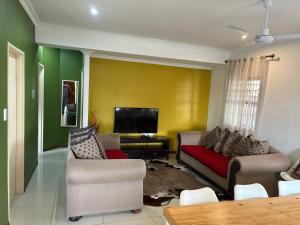 a living room with a couch and a tv at SNE Travellers in Faure