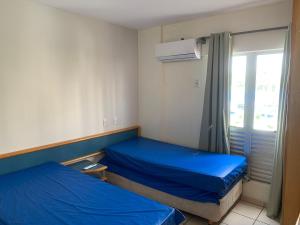 a small room with two beds and a window at Eldorado Thermas Park Localização Top área de Lazer Completa in Caldas Novas +58 photos
