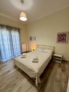 a bedroom with a large bed with white sheets at ESTIA Dionysos in Drama