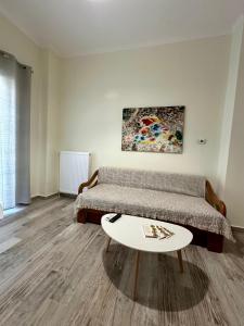 a room with two beds and a coffee table at ESTIA Dionysos in Drama