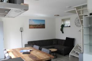 a living room with a couch and a table at Hoge achterom in Den Hoorn