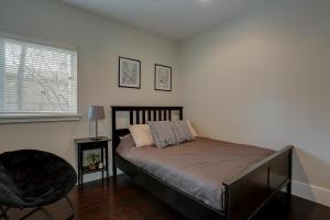 ein Schlafzimmer mit einem Bett und einem Stuhl und einem Fenster in der Unterkunft Surf's Up 30 Day Minimum in Hood River