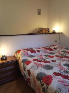 a bedroom with a bed with a floral comforter at La caciaia di Bulcianella in Pieve Santo Stefano