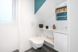 a white bathroom with a toilet and a sink at Les clos des Aviateurs in Strasbourg +11 photos