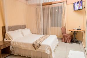 a hotel room with a bed and a television at ETON Hotel in Thika