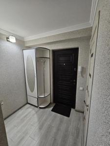 an empty room with a refrigerator and a door at Buiucani in Chişinău