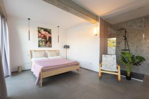 a bedroom with a bed and a chair in it at Tropicana Suite - Adults Only in Agropoli +100 photos