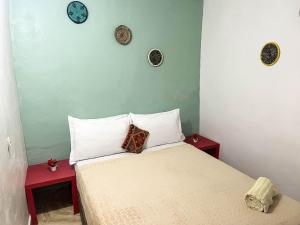 a bedroom with a bed with two tables and clocks on the wall at Superbo Stay Sea View Surf House near Taghazout Panoramic Terrace in Taghazout +94 photos