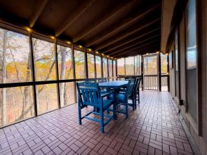 BaxterChalet w Hot Tub Fireplace Grill FirePit & Wifi的窗户门廊上的桌椅