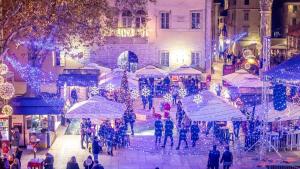 um grupo de pessoas andando por uma rua com luzes de Natal em Villa Madison, Spacious Sea View Apartments Near Zadar Advent and Winter Activities em Posedarje mais 74 fotografias