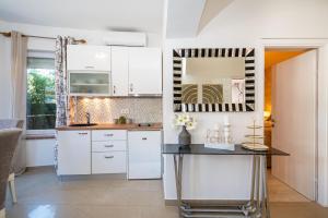 eine Küche mit weißen Schränken und einem Tisch in der Unterkunft Villa Renata ZadarVillas in Zaton + 17 Fotos