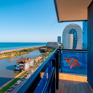 ein Balkon mit Blick auf den Hafen und die Stadt in der Unterkunft VIP CLASS ꙳ ORBI CITY in Batumi