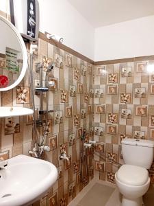 a bathroom with a toilet and a sink and a mirror at Sunflower House Weligama in Weligama