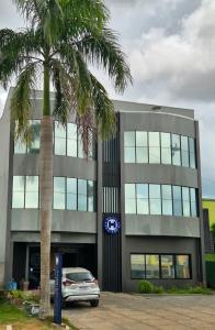 a car parked in front of a building with a palm tree at Hotel Sul Real in Ji-Paraná