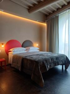 Un dormitorio con una cama y una ventana grande. en Vistaperdue, en Peccioli