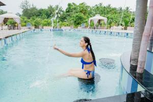 une femme en bikini assise dans une piscine dans l'établissement Silver Sand Village Resort, à Havelock Island