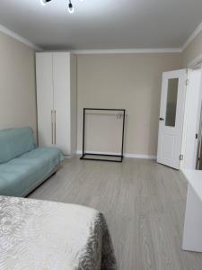 PrigorodnyyKvartira Astana的一间带床和沙发的白色房间