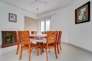 SingānallūrNirvana 4BHK by Palette | DanCenter的餐厅里有一张桌子和几把椅子