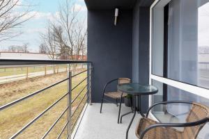 balcón con mesa, sillas y vistas a un campo en Unique Studio with Balcony in Jastrzębia Góra by Noclegi Renters, en Tupadły