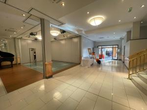 Großes Zimmer mit einem Klavier und einem Tisch in der Unterkunft The Mansefield Hotel in Elgin