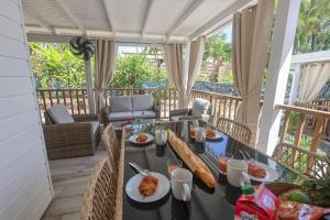 ein Tisch mit Tellern voller Essen auf einem Balkon in der Unterkunft L'Escapade Créole in Saint-François