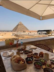 una mesa con comida y vistas a las pirámides en Aurum Pyramids View, en El Cairo