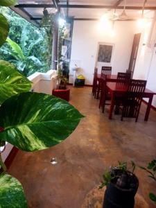 a living room with a table and chairs and plants at Sunflower House Weligama in Weligama