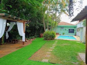 ein Hinterhof mit einem Swimmingpool und einem Haus in der Unterkunft Open House Timboré in São Paulo