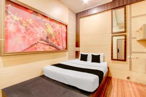 SeturanにあるHotel O near Maguwoharjo Stadium formerly Graha Ngasoの壁に絵が飾られたベッドのある寝室