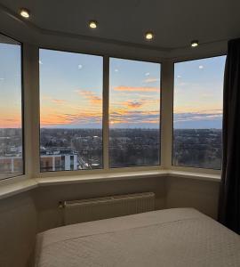 1 dormitorio con ventanas y vistas a la ciudad en Стильна, затишна, простора квартира в центрі, en Cherkasy