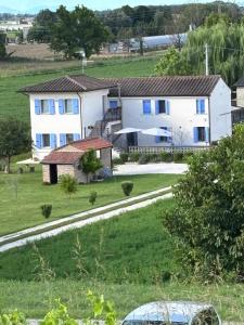 a white house with blue windows and a road at B&B Lilla All'Adige in Legnago +5 photos