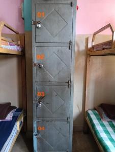 una puerta de metal en una habitación con dos literas en V R S Dormitory, en Hubli