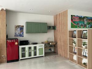 a kitchen with a red refrigerator and green cabinets at NAKA GUEST HOUSE in Ban Ko Kwang