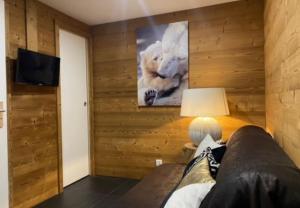 a man sitting on a couch in a room with wooden walls at Chalet Cosy in Pugny-Chatenod