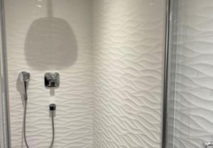 a shower with a glass door and a mirror at Chalet Cosy in Pugny-Chatenod +22 photos