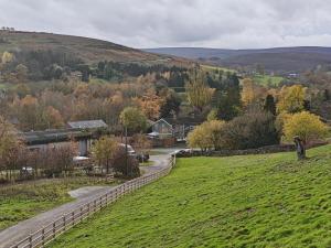 a green field with a fence and a road at 2 Bed in Castleton oc-p34012 in Castleton