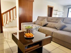 a living room with a couch and a bowl of oranges on a table at ENJOY House with Large Pool & Jacuzzi in Los Estancos