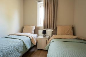 two beds in a small bedroom with a window at Mondri in Winterswijk