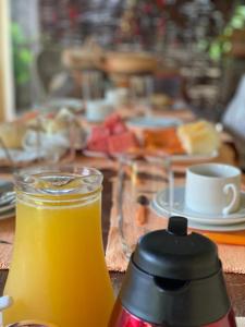 a table with a jar of orange juice and plates of food at Parador Algaroba in Japaratinga