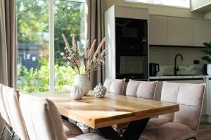 a dining room table with a vase of flowers on it at Mondri in Winterswijk