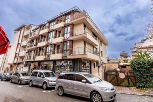 zwei Autos vor einem Gebäude geparkt in der Unterkunft City Home Sandanski in Sandanski