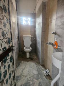 Un baño pequeño con inodoro y lavabo. en Pandit Devki Nandan Dharamsala & Guest House, en Deoghar
