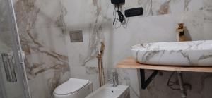 um banheiro branco com uma pia e um vaso sanitário em PRINCIPE ROOMS em Rodigo