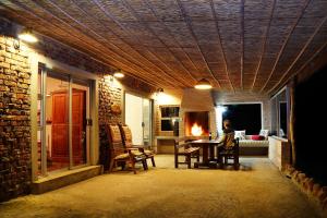 Una habitación con una mesa y sillas y una chimenea. en Skeiding Guest Farm, en Heidelberg