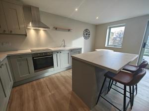 a kitchen with a counter and a kitchen island with two stools at 2 Bed in Castleton oc-f34013 in Castleton +4 photos