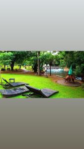 um grupo de espreguiçadeiras na relva de um parque em Thermas Paradise resorts em Rio Quente mais 3 fotografias