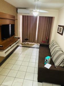 uma sala de estar com um sofá e uma TV de tela plana em Thermas Paradise resorts em Rio Quente